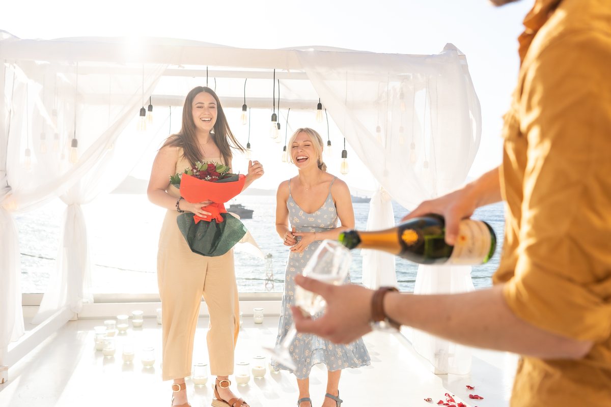 Champagne poured on AION's terrace, the caldera behind