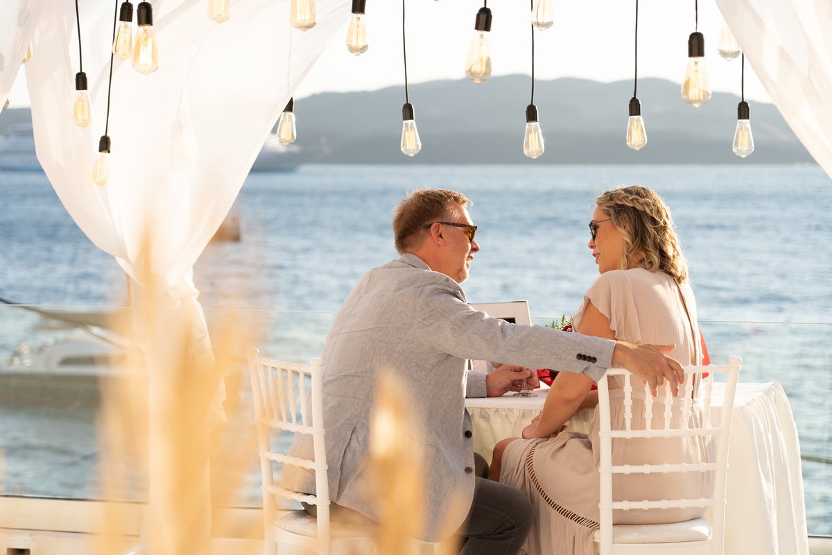 Dinner for two served on the private terrace at AION, drapes drawn back to the sea