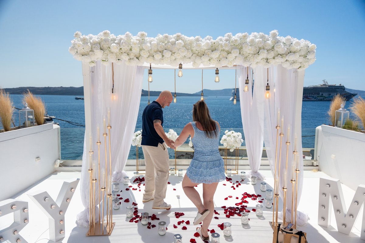AION's terrace set for a proposal — the white arch, MARRY ME letters and rose petals to the sea