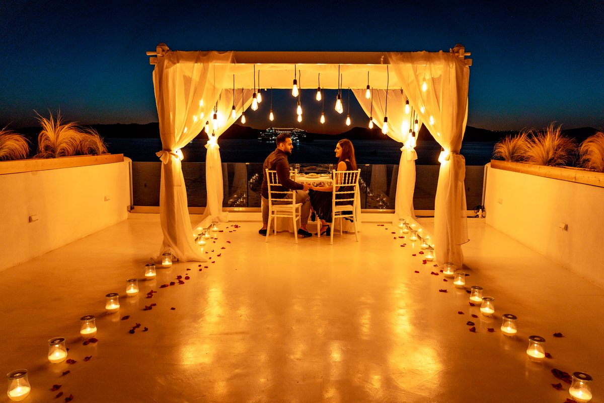 AION's terrace at night — the ceremony arch lit, candles down the whole length of the floor