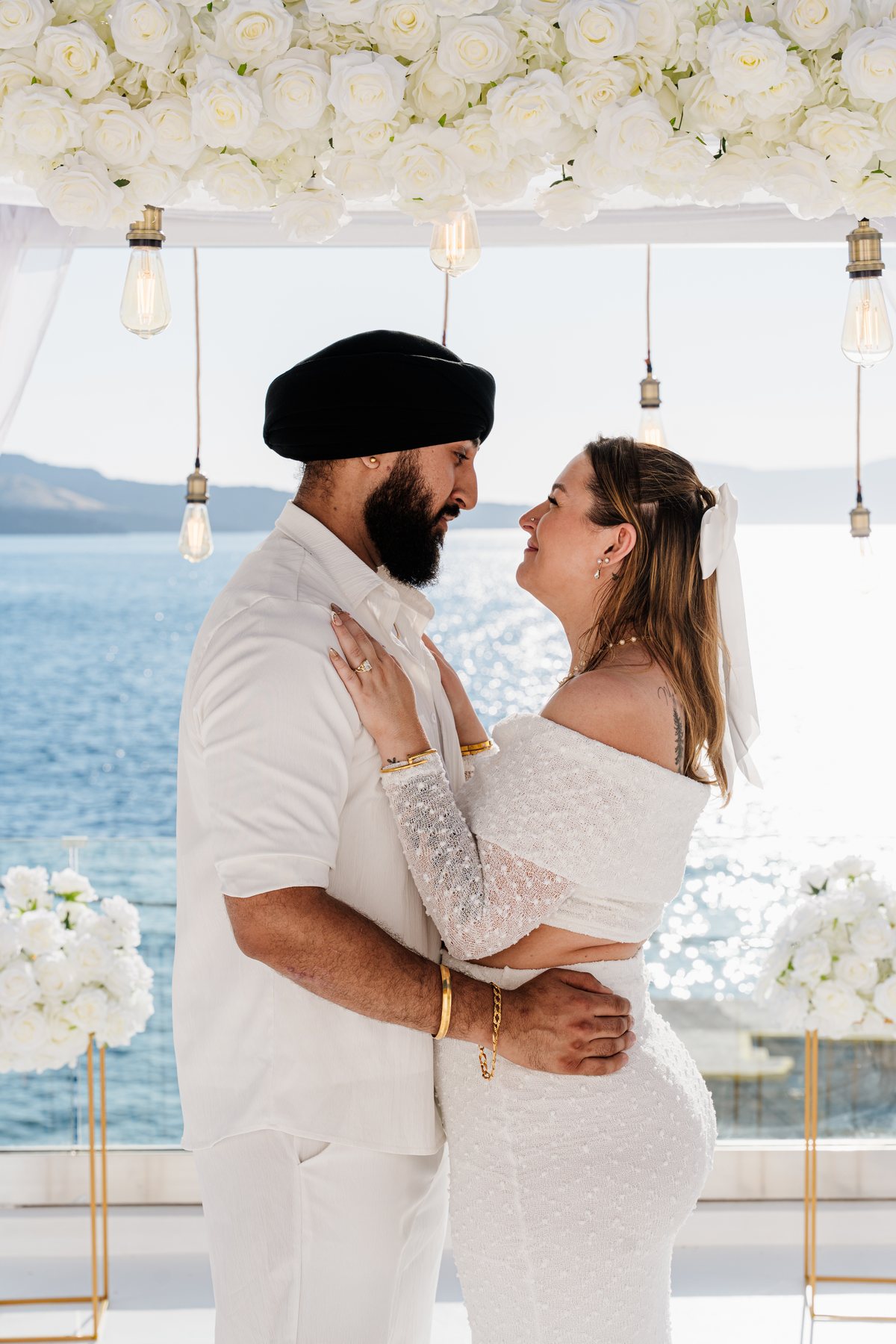 A wedding portrait on AION's terrace, white flowers above and the sea below