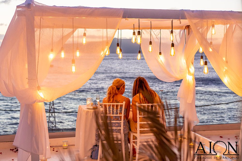 Just engaged - the two of them at the table under the canopy, facing the sea