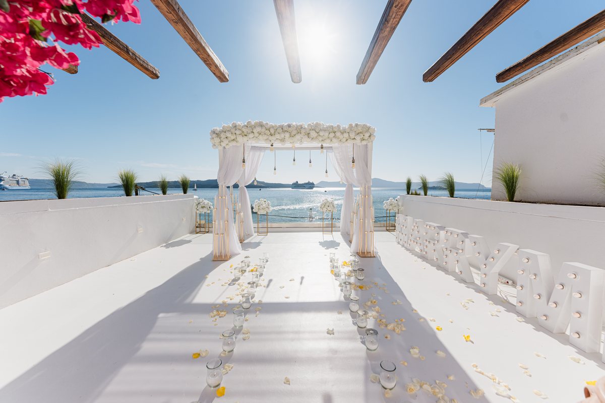 AION's terrace set for an evening event, the white aisle running to the water