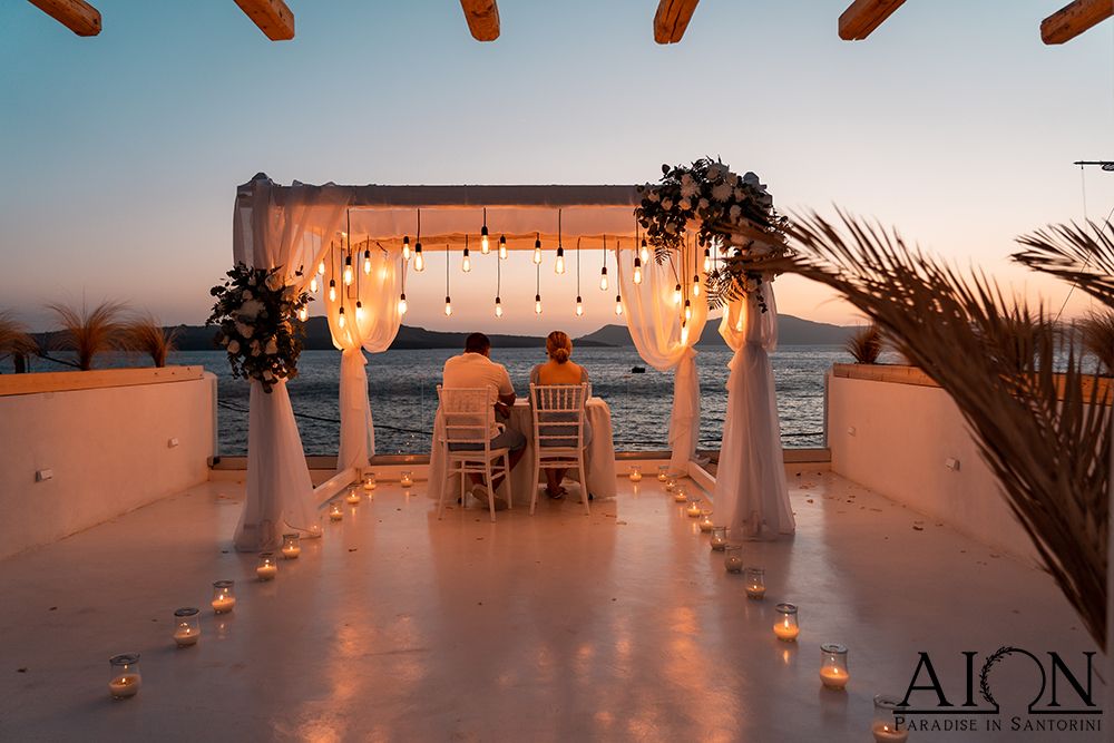 The terrace laid for the private dinner - canopy, candles and rose petals at dusk